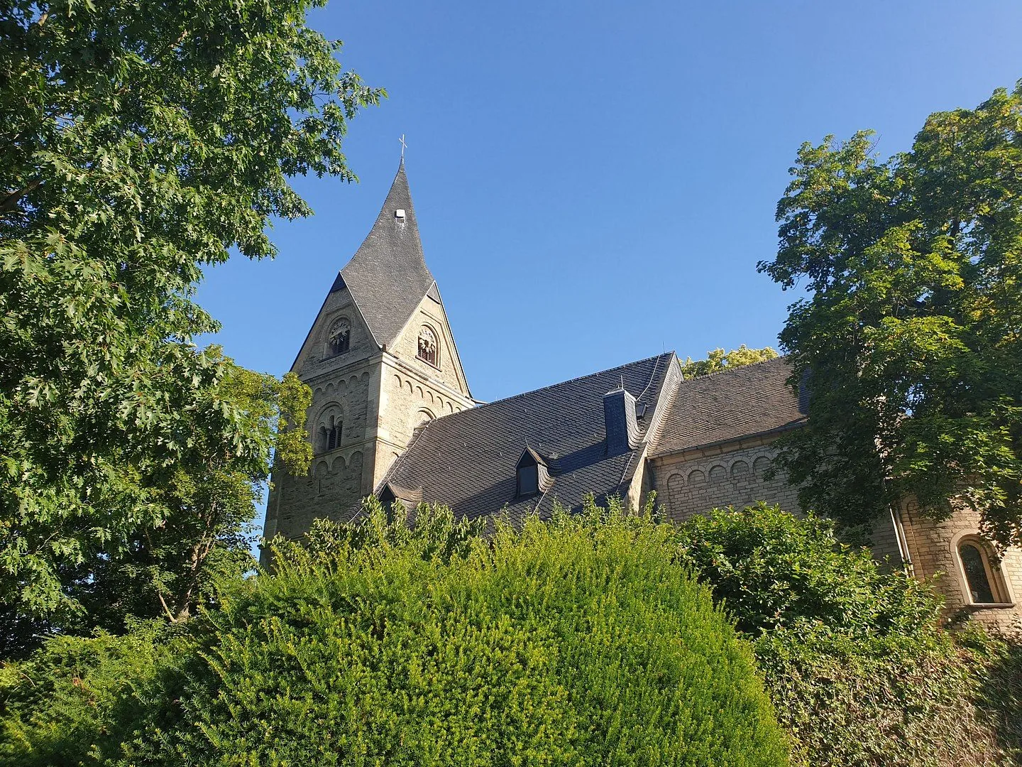 Feldkirche mit Gemeindehaus und Osterglocken im Vordergrund